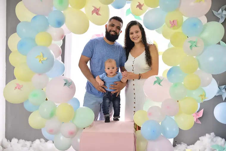 Família com bebê em cenário de balões